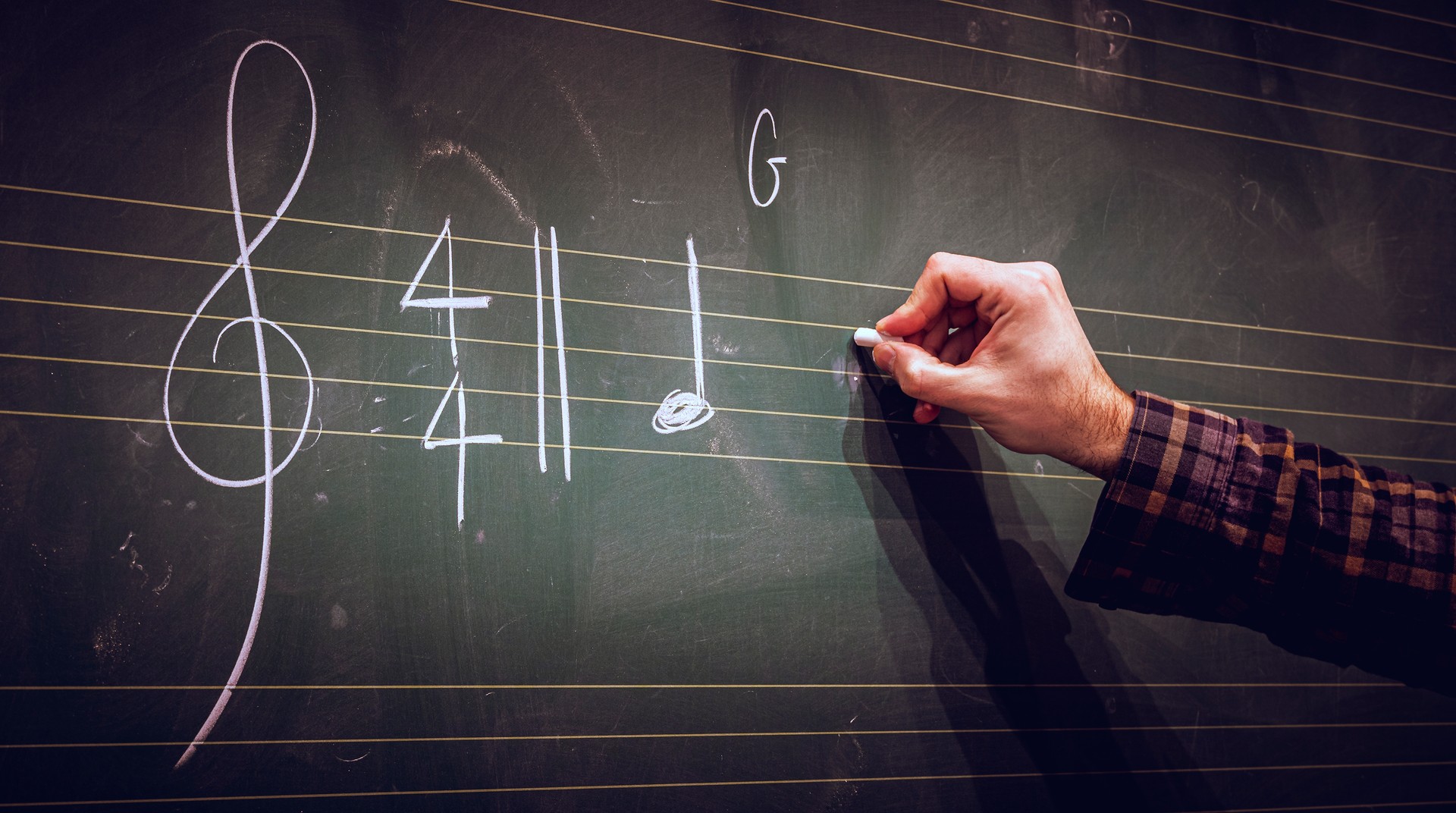 Scrivere a mano note musicali su una partitura su lavagna con gesso bianco. Composizione musicale o concetto di formazione o istruzione.